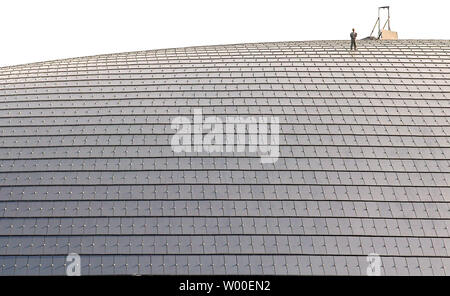 Un travailleur de la construction marche sur le haut de l'oeuf-comme la Dome du Grand Théâtre national chinois au centre-ville de Pékin, le 3 juillet 2006. Le controversé projet de construction est en voie d'achèvement et de l'intérieur seront terminés d'ici la fin de l'année. Conçu par l'architecte français Paul Andreu, les travaux ont commencé en décembre 2001 après quatre années de délibérations entre les décideurs. (UPI Photo/Stephen Shaver) Banque D'Images