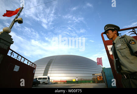 Un garde de sécurité chinois se dresse à l'entrée des travailleurs de l'oeuf-comme la Dome du Grand Théâtre national chinois au centre-ville de Beijing, le 18 octobre 2006. La construction controversée, même s'il est presque terminé, a rencontré des difficultés financières qui menacent de retarder considérablement son achèvement. Conçu par l'architecte français Paul Andreu, les travaux ont commencé en décembre 2001 après quatre années de délibérations entre les décideurs. (UPI Photo/Stephen Shaver) Banque D'Images