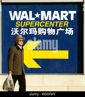 Un vieil homme chinois porte son épicerie d'un arrêt de bus après le shopping dans un nouveau massif, Wal-Mart Supercenter dans le centre-ville de Beijing, Chine, le 17 janvier 2007. Wal-Mart, le plus grand détaillant, cherche à étendre de magasins en Chine qui est déjà la source d'une grande partie de sa marchandise. (UPI Photo/Stephen Shaver) Banque D'Images