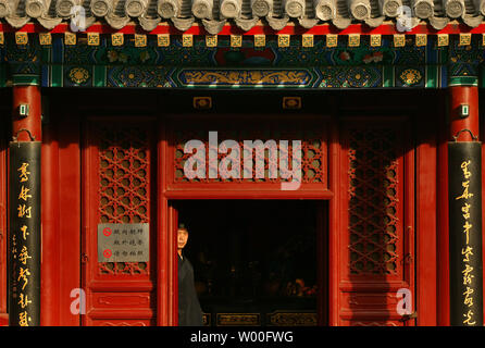 Un Toaist monk se tient dans l'embrasure d'une salle de culte à l'intérieur du Temple taoïste Baiyunguan, dans le centre de Pékin, Chine le 17 février 2007. (UPI Photo/Stephen Shaver) Banque D'Images