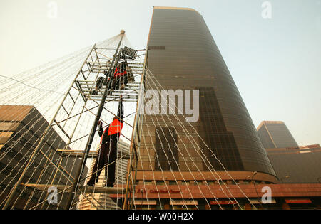 Les travailleurs chinois ont mis en place les décorations de Noël en face d'immeubles de bureaux au centre-ville de Beijing, Chine Le 28 novembre 2007. Capitale de la Chine c'est d'attraper la fièvre de Noël comme la plupart des nouveaux centres commerciaux de Pékin moderne sont ornées d'arbres, le thistle, rubans et de cloches en prévision d'une augmentation de la demande de produits dérivés et de shopping. (UPI Photo/Stephen Shaver) Banque D'Images