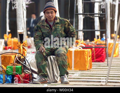 Les travailleurs chinois ont mis en place les décorations de Noël en face d'immeubles de bureaux au centre-ville de Beijing, Chine Le 28 novembre 2007. Capitale de la Chine c'est d'attraper la fièvre de Noël comme la plupart des nouveaux centres commerciaux de Pékin moderne sont ornées d'arbres, le thistle, rubans et de cloches en prévision d'une augmentation de la demande de produits dérivés et de shopping. (UPI Photo/Stephen Shaver) Banque D'Images