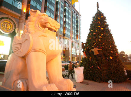 Les travailleurs chinois ont mis en place les décorations de Noël en face d'immeubles de bureaux au centre-ville de Beijing, Chine Le 28 novembre 2007. Capitale de la Chine c'est d'attraper la fièvre de Noël comme la plupart des nouveaux centres commerciaux de Pékin moderne sont ornées d'arbres, le thistle, rubans et de cloches en prévision d'une augmentation de la demande de produits dérivés et de shopping. (UPI Photo/Stephen Shaver) Banque D'Images