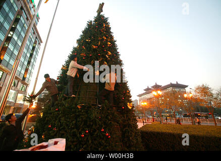 Les travailleurs chinois ont mis en place les décorations de Noël en face d'immeubles de bureaux au centre-ville de Beijing, Chine Le 28 novembre 2007. Capitale de la Chine c'est d'attraper la fièvre de Noël comme la plupart des nouveaux centres commerciaux de Pékin moderne sont ornées d'arbres, le thistle, rubans et de cloches en prévision d'une augmentation de la demande de produits dérivés et de shopping. (UPI Photo/Stephen Shaver) Banque D'Images