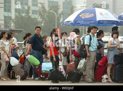 Les longues files de voyageurs chinois attendre dans une file d'attente de taxi après son arrivée à l'une des stations de train de Pékin, le 26 juillet 2008. En raison de contrôles de trafic visant à réduire la pollution dans les préparatifs en vue des Jeux olympiques le mois prochain, les résidents et les touristes ont des lignes d'une longueur inhabituelle pour les autobus, le métro et les taxis. (UPI Photo/Stephen Shaver) Banque D'Images