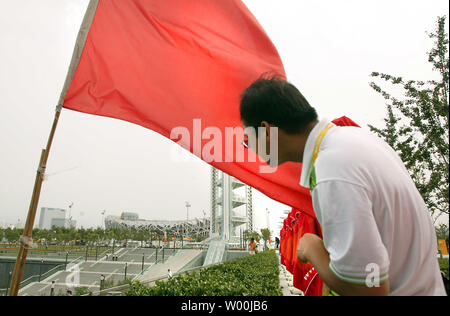 Un volontaire olympique sur les Jeux Olympiques de la Chine regarde vert Stade National Olympique, aussi connu comme le Nid d'oiseau, à Beijing le 29 juillet 2008. (UPI Photo/Stephen Shaver) Banque D'Images