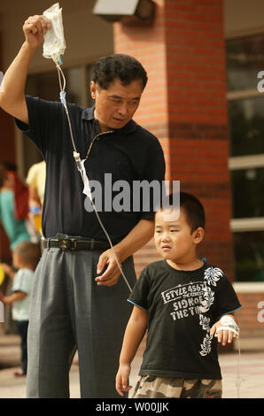 Un père chinois apporte son fils à l'un des principaux de la Beijing children's hospital le 23 septembre 2008. La Chine a promis d'arrêter le lait toxique d'atteindre les transformateurs et les marchés d'exportation après la poudre contaminé plus de 54 000 enfants malades dans un scandale qui a plongé la réputation commerciale du pays dans une nouvelle crise. (UPI Photo/Stephen Shaver) Banque D'Images