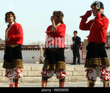 Un agent de sécurité surveille les artistes chinois, sur les voitures qu'ils travaillent à une réplique d'un Temple autel à Lhassa, Tibet qui représente une partie des 56 groupes ethniques présentées par les Chinois Han de Beijing en Chine, ou Musée des nationalités ethniques chinois Parc Culturel, le 15 mars 2009. La Chine a accusé le Congrès des États-Unis la semaine dernière d'endommager les relations et s'ingérer dans les affaires intérieures de la Chine en adoptant une résolution sur la reconnaissance de la situation critique des personnes et du Tibet en exil de leur chef spirituel, le Dalaï Lama. (UPI Photo/Stephen Shaver) Banque D'Images
