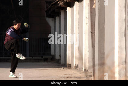 Une vieille femme chinoise arts martiaux pratiques sous le soleil d'après-midi à Beijing le 26 décembre 2009. La Chine peut être aller de l'avant en tant que puissance mondiale, mais il commence aussi à faire face à l'effet à long terme de sa politique de l'enfant - trop de personnes âgées et pas assez de jeunes. La Chine a le plus grand nombre de personnes âgées dans le monde, avec des estimations officielles de 143 millions de dollars, soit un cinquième du total mondial. UPI/Stephen Shaver Banque D'Images