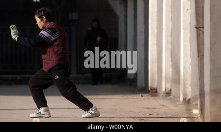 Une vieille femme chinoise arts martiaux pratiques sous le soleil d'après-midi à Beijing le 26 décembre 2009. La Chine peut être aller de l'avant en tant que puissance mondiale, mais il commence aussi à faire face à l'effet à long terme de sa politique de l'enfant - trop de personnes âgées et pas assez de jeunes. La Chine a le plus grand nombre de personnes âgées dans le monde, avec des estimations officielles de 143 millions de dollars, soit un cinquième du total mondial. UPI/Stephen Shaver Banque D'Images