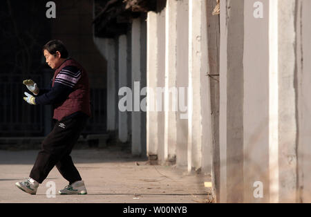 Une vieille femme chinoise arts martiaux pratiques sous le soleil d'après-midi à Beijing le 26 décembre 2009. La Chine peut être aller de l'avant en tant que puissance mondiale, mais il commence aussi à faire face à l'effet à long terme de sa politique de l'enfant - trop de personnes âgées et pas assez de jeunes. La Chine a le plus grand nombre de personnes âgées dans le monde, avec des estimations officielles de 143 millions de dollars, soit un cinquième du total mondial. UPI/Stephen Shaver Banque D'Images