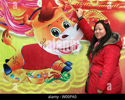 Une femme chinoise pose pour une photo à côté d'une 'bonne chance' la peinture à une foire du temple pendant la fête du printemps chaque année, en inaugurant l'année du Tigre, à Beijing le 19 février 2010. Le Nouvel An chinois, ou Fête du Printemps, est la plus grande maison de la Chine, les travailleurs migrants donnant leur seule chance de retourner dans leurs provinces d'origine avec des cadeaux et de l'argent pour la famille. Il représente la plus grande migration de masse annuelle de l'homme. UPI/Stephen Shaver Banque D'Images