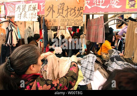 Les acheteurs chinois pour chasser l'impromptu de vêtements outdoor et ménagers marché à Beijing le 13 octobre 2010. Avec l'essor des sentiments des consommateurs parmi les économies asiatiques flouring, surtout en Chine, les détaillants se préparent les efforts visant à stimuler la consommation dans un large éventail de biens de consommation de première nécessité pour les produits de luxe. UPI/Stephen Shaver Banque D'Images