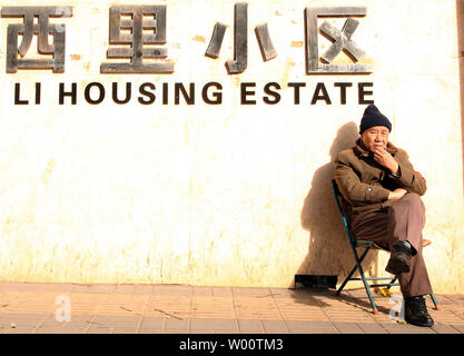 Un vieil homme est assis chinois dans le chaud soleil de fin d'après-midi, à l'extérieur d'un logement ancien dans le centre de Pékin, le 22 novembre 2010. Capitale de la Chine devra s'attaquer au défi du vieillissement de la population au cours des cinq dernières années et la ville n'a que peu d'expérience dans les rapports avec le phénomène, en fonction de l'état de la presse. UPI/Stephen Shaver Banque D'Images