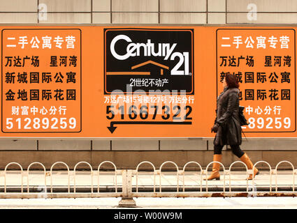 Une femme chinoise passe devant un grand panneau d'affichage de l'entreprise américaine le géant de l'immobilier Century 21, maintenant de faire des affaires en Chine, dans le centre de Pékin, le 16 février 2011. Des centaines de sociétés américaines sont l'ouverture de bureaux en Chine dans l'espoir de profiter de l'essor de l'économie du pays, qui a adopté le Japon comme officiellement la deuxième économie du monde. UPI/Stephen Shaver Banque D'Images