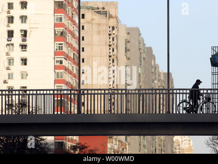 Un Chinois chevauche son vélo cours des nouveaux ensembles immobiliers au centre-ville de Beijing, le 11 mars 2011. Après les dépassements les Etats-Unis comme le plus grand marché de la construction en 2010, le secteur de la construction sera doublée à 2,5 trillions de dollars en 2020. UPI/Stephen Shaver Banque D'Images