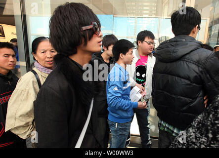 Des groupes de Chinois s'attarder à l'extérieur du magasin phare d'Apple dans l'espoir de la corruption pour les acheteurs leur carte d'identité afin d'acheter des iPhones à Beijing le 3 avril 2011. Les hommes, qui paient en espèces et utiliser 'mules' d'acheter jusqu'à 60 iPhones par jour, alors à la vente des téléphones portables à des prix plus élevés en dehors de Beijing. Limites Apple achète à deux iphone par personne, et pour décourager les visites répétées il tient un registre des cartes de crédit utilisées, mais les achats en espèces ne sont pas suivis. Apple dit la limite 'aide à s'assurer qu'il y a suffisamment d'iphone pour les personnes qui font des achats pour eux-mêmes ou d'acheter un cadeau." Banque D'Images