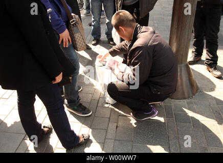 Des groupes de Chinois s'attarder à l'extérieur du magasin phare d'Apple dans l'espoir de la corruption pour les acheteurs leur carte d'identité afin d'acheter des iPhones à Beijing le 3 avril 2011. Les hommes, qui paient en espèces et utiliser 'mules' d'acheter jusqu'à 60 iPhones par jour, alors à la vente des téléphones portables à des prix plus élevés en dehors de Beijing. Limites Apple achète à deux iphone par personne, et pour décourager les visites répétées il tient un registre des cartes de crédit utilisées, mais les achats en espèces ne sont pas suivis. Apple dit la limite 'aide à s'assurer qu'il y a suffisamment d'iphone pour les personnes qui font des achats pour eux-mêmes ou d'acheter un cadeau." Banque D'Images