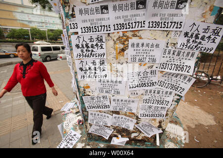 Des chinois de la base d'un pôle lumière recouvert d 'achat et vente' autocollants à Beijing le 12 mai 2011. Le gouvernement chinois va augmenter ses livraisons de terrains disponibles pour le développement de l'habitation cette année dans le cadre du pays dans ses efforts pour réduire ses runaway marché de l'immobilier, selon le ministère des Terres et des ressources. UPI/Stephen Shaver Banque D'Images