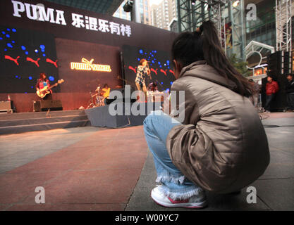 Un groupe de rock chinois embauchés par Puma, l'un des principaux sports Société de vie, joue de la musique américaine couvre lors d'un événement marketing public au plan international fashion mall à Beijing le 5 novembre 2011. Les entreprises étrangères dans l'espoir de faire des affaires en Chine engagent souvent des musiciens locaux, des célébrités et des athlètes pour aider à promouvoir leur marque au plus grand marché de consommation au monde. UPI/Stephen Shaver Banque D'Images