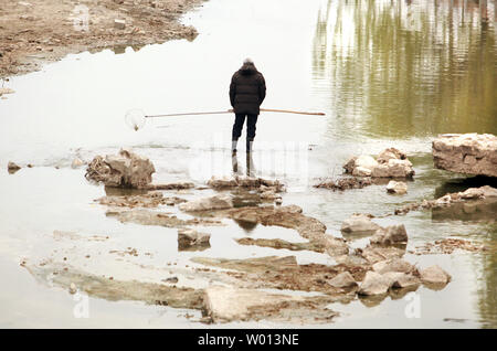 Un chinois tente de capturer de petits poissons dans un lit d'une rivière asséchée à Beijing le 20 novembre 2013. Surmonter les hauts niveaux de pauvreté et de chômage dans tout le pays reste un défi majeur pour la Chine. UPI/Stephen Shaver Banque D'Images