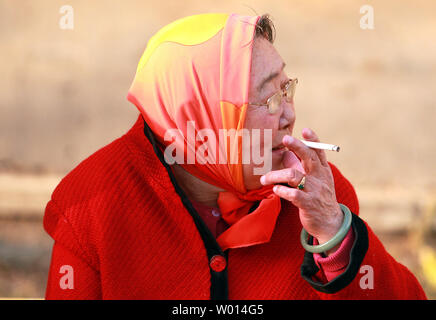 Une vieille femme chinoise fume une cigarette à Beijing le 4 mars 2014. La Chine a besoin de prendre une position plus ferme contre la puissance de l'industrie du tabac s'il espère réduire les quelque 1 millions de décès liés au tabagisme le pays voit chaque année, selon l'Organisation mondiale de la santé. UPI/Stephen Shaver Banque D'Images