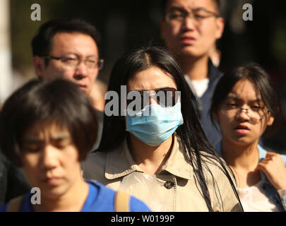 Une femme chinoise porte un masque de visage comme elle marche dans la rue à Beijing le 11 octobre 2015. Les groupes environnementaux en Chine a publié un rapport plus tôt cette année sur plus de 1 000 entreprises qui disent-ils dépassent régulièrement les normes d'émissions, une tentative de "nommer et stigmatiser" les industries chinoises qui sont en partie responsables de la prise de nombreuses villes chinoises les plus polluées du monde. Photo par Stephen Shaver/UPI Banque D'Images