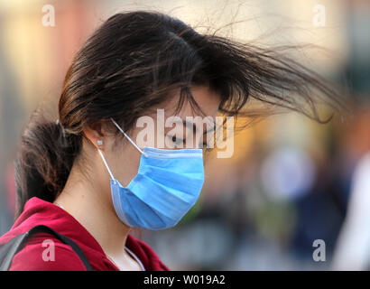 Une femme chinoise porte un masque de visage comme elle marche dans la rue à Beijing le 11 octobre 2015. Les groupes environnementaux en Chine a publié un rapport plus tôt cette année sur plus de 1 000 entreprises qui disent-ils dépassent régulièrement les normes d'émissions, une tentative de "nommer et stigmatiser" les industries chinoises qui sont en partie responsables de la prise de nombreuses villes chinoises les plus polluées du monde. Photo par Stephen Shaver/UPI Banque D'Images
