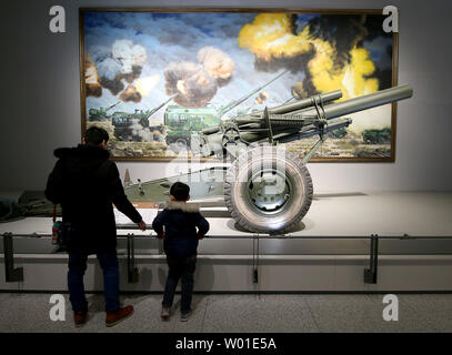Les visiteurs chinois regarder un obusier américain à l'affiche au Musée militaire de Pékin le 6 février 2018. La Chine, qui maintient la plus grande armée permanente dans le monde, a mené avec succès un autre test de missile anti-tensions de plus en plus de l'amide armes nucléaires de la Corée du Nord et le programme de militarisation de la mer de Chine du Sud. Photo par Stephen Shaver/UPI Banque D'Images
