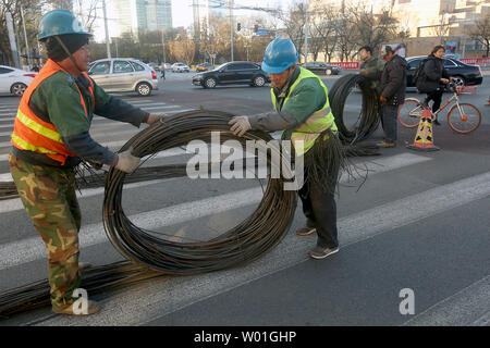 Les travailleurs chinois se détendre de grandes bobines de fils dans une rue de Beijing le 11 janvier 2019. Le gouvernement prévoit une croissance économique plus faible cible de 6-6.5  % en 2019 après 6,6 % prévu en 2018, ce qui serait la plus faible expansion depuis 1990, selon des sources politiques. Photo par Stephen Shaver/UPI Banque D'Images