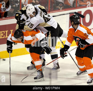 Pittsburgh Penguins aile gauche Dustin Jeffrey presque saute sur haut de Flyers de Philadelphie Darroll Powe centre comme ils bataille pour la rondelle au cours de troisième période Philadelphie Pingouins Flyers-Pittsburgh NHL hockey à la Wells Fargo Center de Philadelphie, le 24 mars 2011. Regarder est Philadelphia's Nick Boynton (24). Pittsburgh défait Philadelphie 2-1 dans une fusillade. UPI/John Anderson Banque D'Images