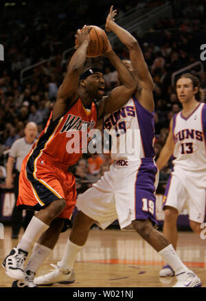 Golden State Warrior Baron Davis disques durs pour le godet avec Phoenix Suns' Raja Bell défendre au premier semestre le 12 janvier 2006 à Phoenix, AZ. (Photo d'UPI/Will Powers) Banque D'Images