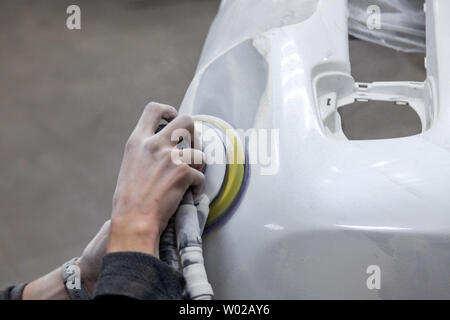 Préparation pour la peinture d'une voiture à l'aide de l'élément sander et putty par un technicien de nivellement avant l'application d'un primaire après l'endommagement d'une partie de Banque D'Images