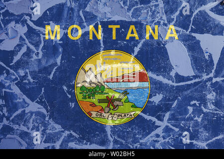 Le drapeau national de l'Etat américain du Montana en contre un mur gris avec des fissures et défauts sur le jour de l'indépendance, en couleurs bleu et jaune. Polit Banque D'Images