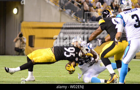 Panthers guard Fernando Velasco (69) apporte les Pittsburgh Steelers linebacker extérieur Jarvis Jones (95) à la suite de la récupération des Panthers quarterback Derek Anderson (3) fumble au stade Heinz Field de Pittsburgh, le 28 août 2014. Panthers guard Fernando Velasco (69) reçoit un collier de cheval de cour 15 s'attaquer à mort sur le jeu. UPI/Archie Carpenter Banque D'Images