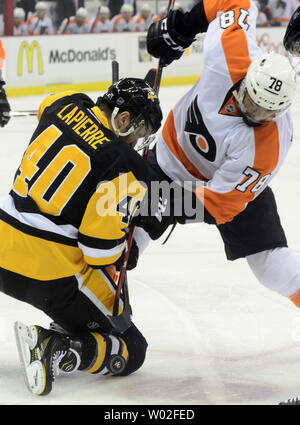 Maxim Lapierre centre des Penguins de Pittsburgh (40) tombe à genoux face à face avec la suite de l'aile droite des Flyers de Philadelphie Pierre-Edouard Bellemare (78) au cours de la première période à la CONSOL Energy Center à Pittsburgh le 1er avril 2015. Photo par Archie Carpenter/UPI Banque D'Images