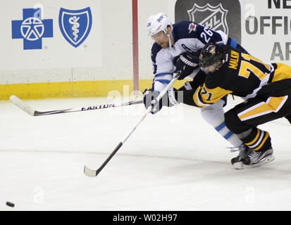 Centre des Penguins de Pittsburgh Evgeni Malkin (71) prend le palet loin des Jets de Winnipeg de l'aile droite Blake Wheeler (26) au cours de la deuxième période de l'empereur gain de 4-1 sur les Jets de Winnipeg au CONSOL Energy Center à Pittsburgh le 27 février 2016. Centre des Penguins de Pittsburgh Evgeni Malkin (71) retourne à la ligne de jeu après avoir raté 10 matchs. Photo par Archie Carpenter/UPI Banque D'Images