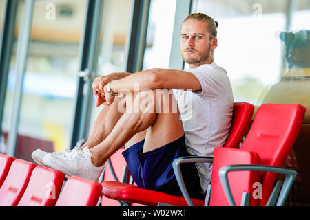 Sandhausen, Allemagne. 25 Juin, 2019. Rurik Gislason, joueur de l'équipe de football de deuxième division SV Sandhausen, est assis sur la tribune du stade pendant une conversation. Gislason de SV Sandhausen est devenu célèbre il y a un an. Non pas parce qu'il a livré des performances sensationnelles pour l'Islande à la Coupe du Monde en Russie, mais à cause de son apparence. (Dpa 'un an après l'exagération : la nouvelle vie de la 'belle' Rurik Gislason') Credit : Uwe Anspach/dpa/Alamy Live News Banque D'Images