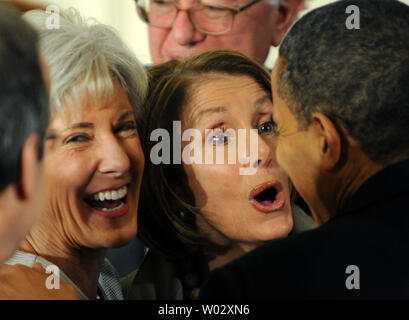 Le président américain Barack Obama (R) est accueilli par le sourire de la Santé et des Services Kathleen Sebelius secrétaire (G) et la présidente de la Chambre Nancy Pelosi, après avoir signé la loi de réforme de l'assurance-santé dans l'East Room de la Maison Blanche à Washington le 23 mars 2010. L'historique de 938 milliards de loi sur les soins de santé sera assurée une couverture pour 32 millions d'Américains non assurés et touchera presque tous les Américains. UPI/Pat Benic Banque D'Images