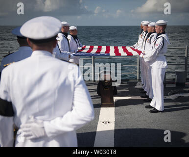 Les membres de l'US Navy Ceremonial Guard tenir un drapeau américain sur l'cremains de Apollo 11 Neil Armstrong astronaute lors d'une inhumation en mer à bord de l'USS mer des Philippines (CG 58) le 14 septembre 2012, dans l'océan Atlantique. Armstrong, le premier homme à marcher sur la lune au cours de la mission Apollo 11 de 1969, est mort samedi, août 25. Il a été 82. UPI//Bill Ingalls/NASA Banque D'Images