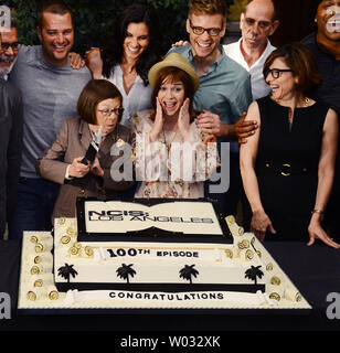 Acteurs Chris O'Donnell, Linda Hunt, Daniela Ruah, Renee Felice Smith Barrett Foa, Miguel Ferrer et L.F. Cool J (L-R), sont reliées par le Président, Nina Tassler Entertainmet CBS (R) au cours de la cérémonie d'un gâteau pour célébrer CBS' 'NCIS : Los Angeles" tournage de leur 100e épisode, qui a eu lieu sur le plateau au Paramount Studios à Los Angeles le 23 août 2013. UPI/Jim Ruymen Banque D'Images