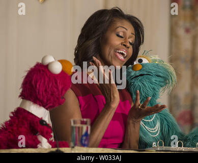 La Première Dame Michelle Obama se joint avec du Sesame Street Elmo et Rosita dans une annonce d'associé d'une campagne de marketing pour aider les enfants à manger des aliments plus sains, lors d'un événement dans la salle à manger d'état de la Maison Blanche à Washington, DC Le 30 octobre 2013. Le trio rejoint ensuite les enfants dans la récolte d'automne annuel de la Maison Blanche Cuisine Jardin. UPI/Pat Benic Banque D'Images