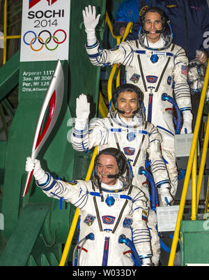 Expedition 38 commandant de Soyouz Mikhail Tyurin de Roscosmos, tenant le flambeau olympique, mécanicien de Koichi Wakata de l'Agence japonaise d'exploration aérospatiale, ingénieur de vol, et Rick Mastracchio de NASA haut, adieu l'onde avant d'embarquer sur le vaisseau Soyouz TMA-11M pour le lancement de fusées au cosmodrome de Baïkonour au Kazakhstan, le 7 novembre 2013. La flamme olympique aura une visite de quatre jours dans la Station spatiale internationale. Tiourine, Mastracchio, et, Wakata passera les six mois à bord de la Station spatiale internationale. UPI/Bill Ingles/NASA Banque D'Images