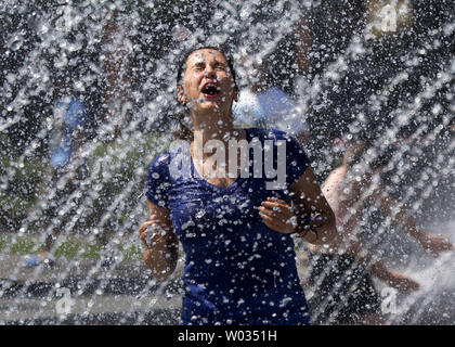 Une femme cools off dans une fontaine au Georgetown Waterfront Park, que les températures haut dans le milieu des années 90 pour la deuxième journée consécutive, à Washington, D.C. le 12 juin 2015. La capitale du pays est au milieu d'une mini vague alors que l'été les températures devraient rester élevé si la fin de semaine. Photo par Kevin Dietsch/UPI Banque D'Images