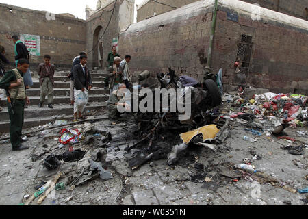 Combattants Houthi inspecter l'épave d'une voiture à l'emplacement d'une attaque près de Qubbat al-Mahdi mosquée de Sanaa, Yémen, le 20 juin 2015. Au moins trois personnes ont été tuées et sept autres personnes ont été blessées lorsqu'une voiture piégée a frappé une mosquée utilisé par le combattants Houthi dans la capitale du Yémen, selon des sources médicales. Photo par Mohammad Abdullah/UPI Banque D'Images