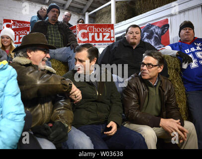 Texas Sen. Ted Cruz, (C), 2016 candidat présidentiel républicain, serre la main avec un supporter comme il est assis avec l'ancien gouverneur du Texas. Rick Perry (R), en attendant de faire des remarques à un événement de campagne dans une grange à Harken Hills Ranch, le 26 janvier 2016, à Osceola, Iowa. Cruz est en marche contre un grand champ de GOP candidats, y compris de magnat de l'immobilier Donald J. Trump, Marco Rubio en Floride Sen. et retraités Ben Carson neurochirurgien de l'avant première de l'Iowa-dans-le-nation de caucus, le 1 février. Photo de Mike Theiler/UPI Banque D'Images