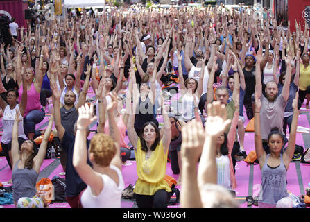 Les gens participent à des cours de yoga à Times Square pour célébrer le solstice d'été à New York le 20 juin 2016. Des milliers de yogis sont censés participer à huit cours de yoga au cours de la 14e conférence annuelle de Solstice dans Times Square : l'esprit du yoga sur la folie d'un jour libre, de long événement yoga. Photo de John Angelillo/UPI Banque D'Images