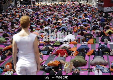 Les gens participent à des cours de yoga à Times Square pour célébrer le solstice d'été à New York le 20 juin 2016. Des milliers de yogis sont censés participer à huit cours de yoga au cours de la 14e conférence annuelle de Solstice dans Times Square : l'esprit du yoga sur la folie d'un jour libre, de long événement yoga. Photo de John Angelillo/UPI Banque D'Images