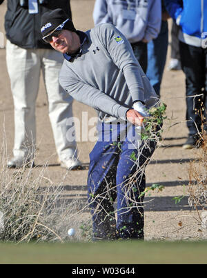 Hunter Mahan saisit plus de bush de balle sur son avant-dernier tir sur le dix-septième trou du parcours de golf de championnat du monde d'Accenture au Golf Club at Dove Mountain de Marana, Arizona le 24 février 2013. Mahan a perdu le championnat à Matt Kuchar. UPI/Art Foxall Banque D'Images