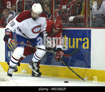 Le défenseur des Canadiens de Montréal Andrei Markov, à gauche, les batailles de l'avant des Hurricanes de la Caroline Doug poids pour le puck dans le premier match de la première ronde de séries éliminatoires de la LNH au RBC Center de Raleigh, N.C. le 22 avril 2006. (Photo d'UPI/Nell Redmond) Banque D'Images
